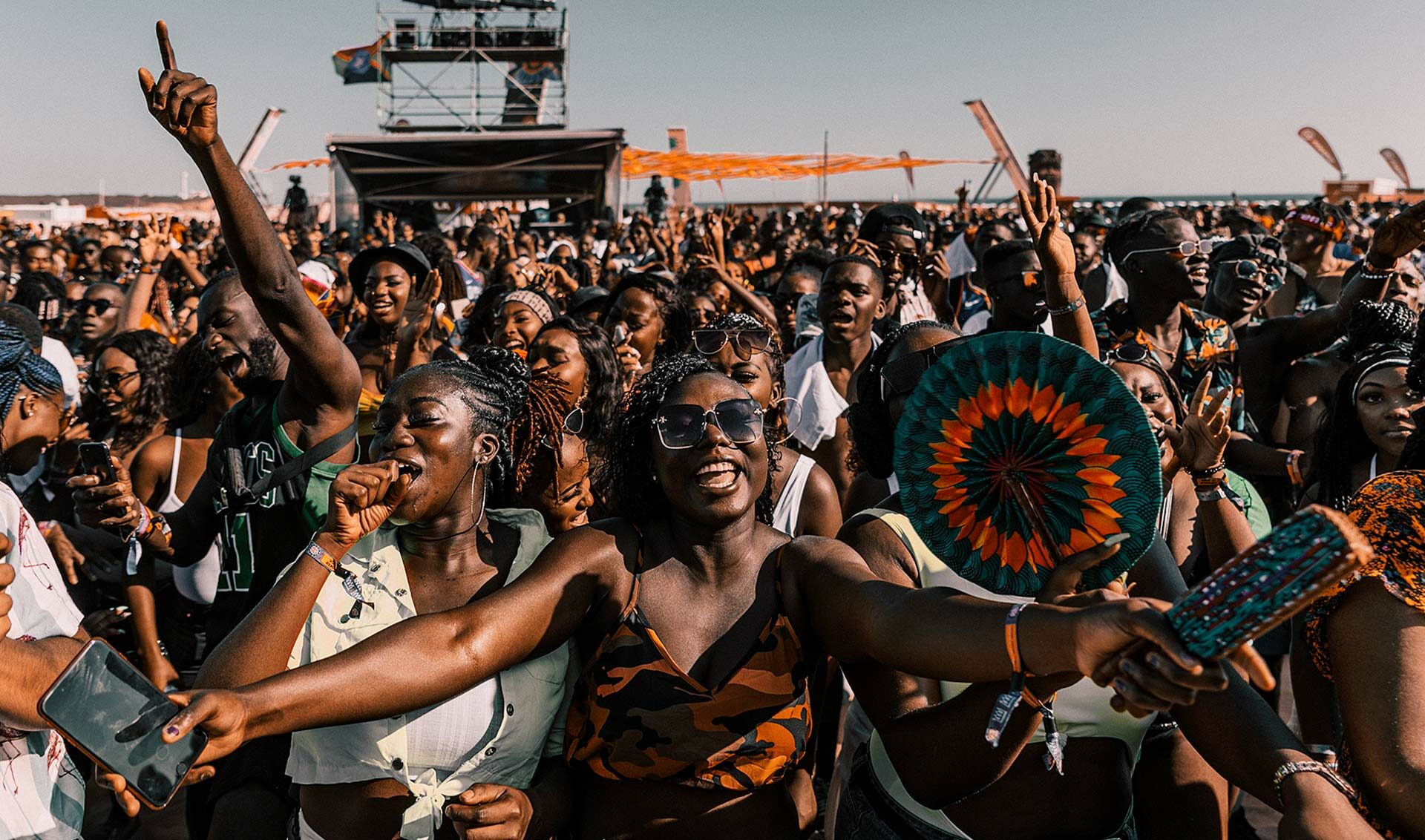 A packed daytime festival crowd dancing and celebrating together